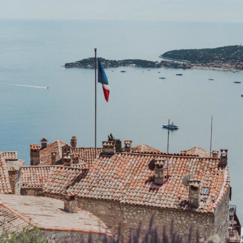 French Flag on Orange Roof Over Coastline